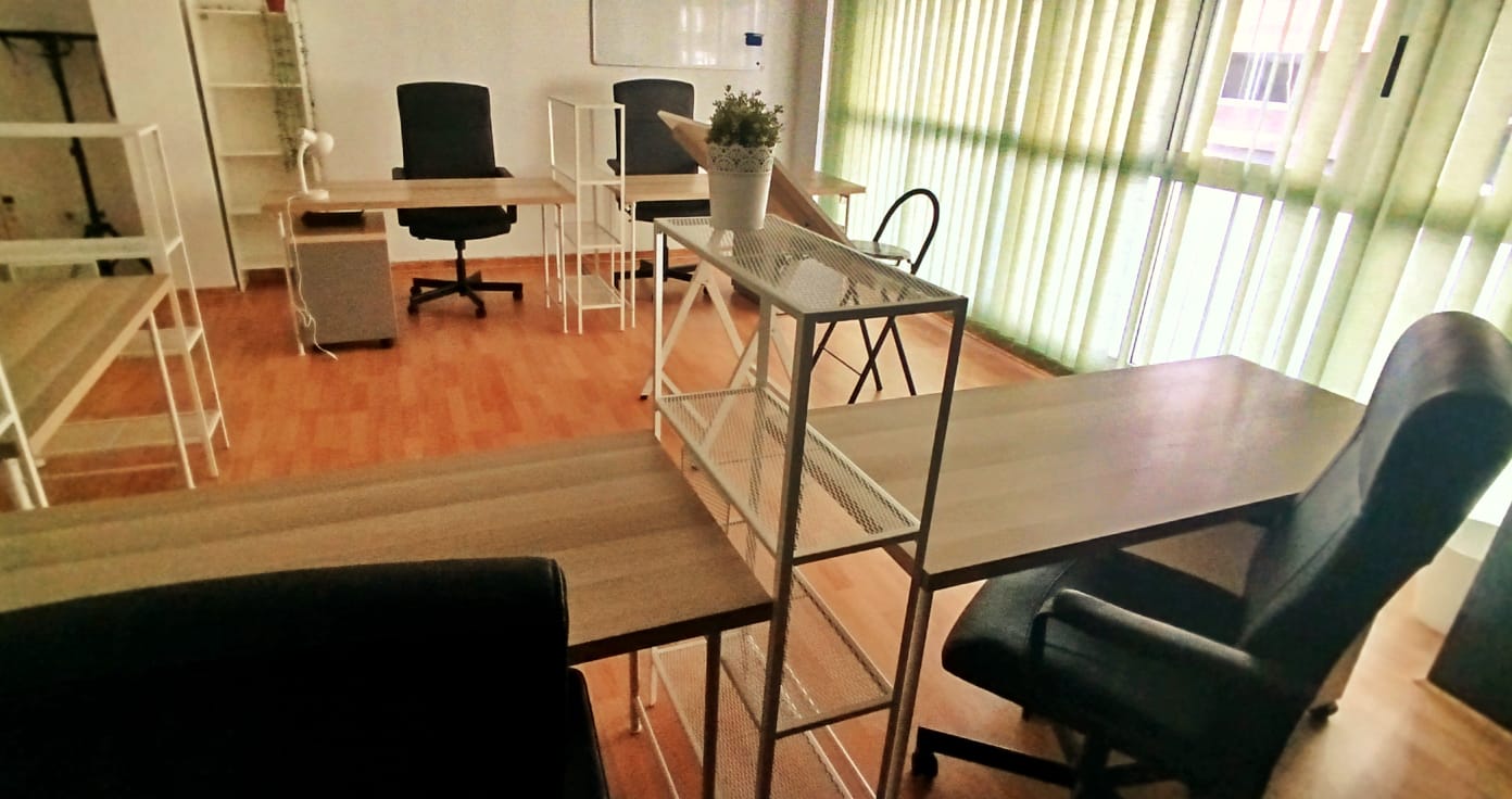 Puestos individuales con mesa, silla ergonómica, cajonera con llave y estantería en el espacio compartido de Tecni Estudio Coworking