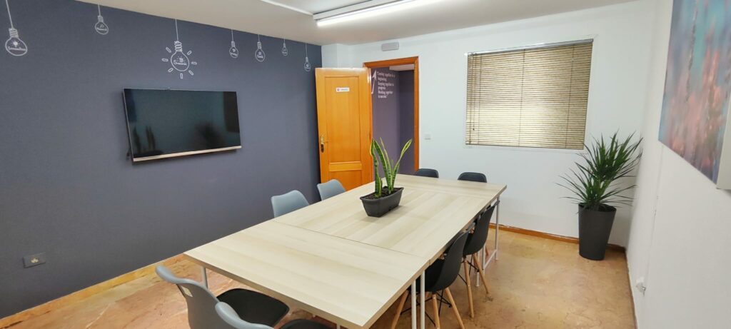 Sala de reuniones con capacidad para 1 a 10 personas, equipada con Smart TV de 42 pulgadas, pizarra y decoración moderna en Tecni Estudio Coworkin