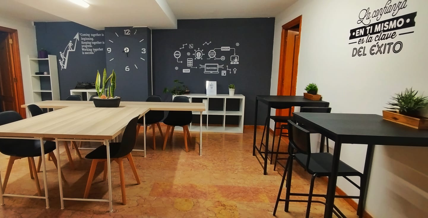 Puestos flexibles en Tecni Estudio Coworking con mesas compartidas, sillas modernas y decoración motivacional