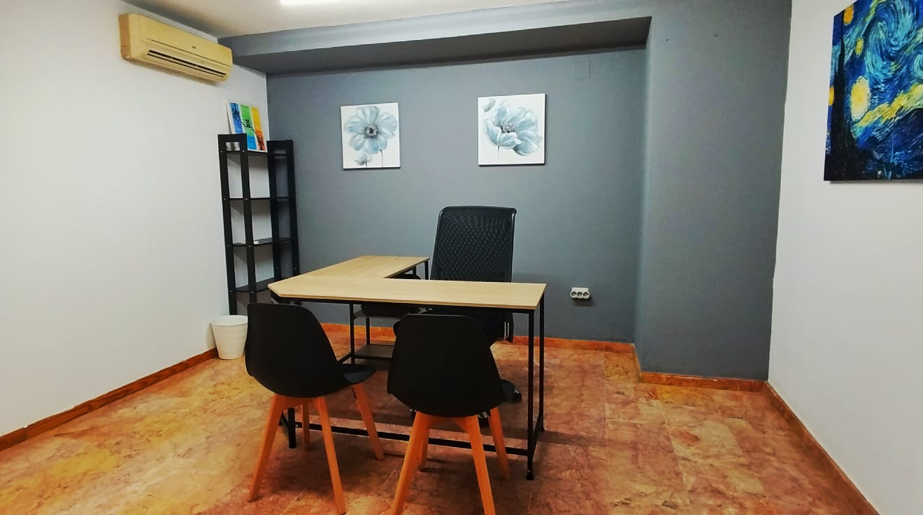 Despacho privado con escritorio, silla ergonómica y decoración minimalista