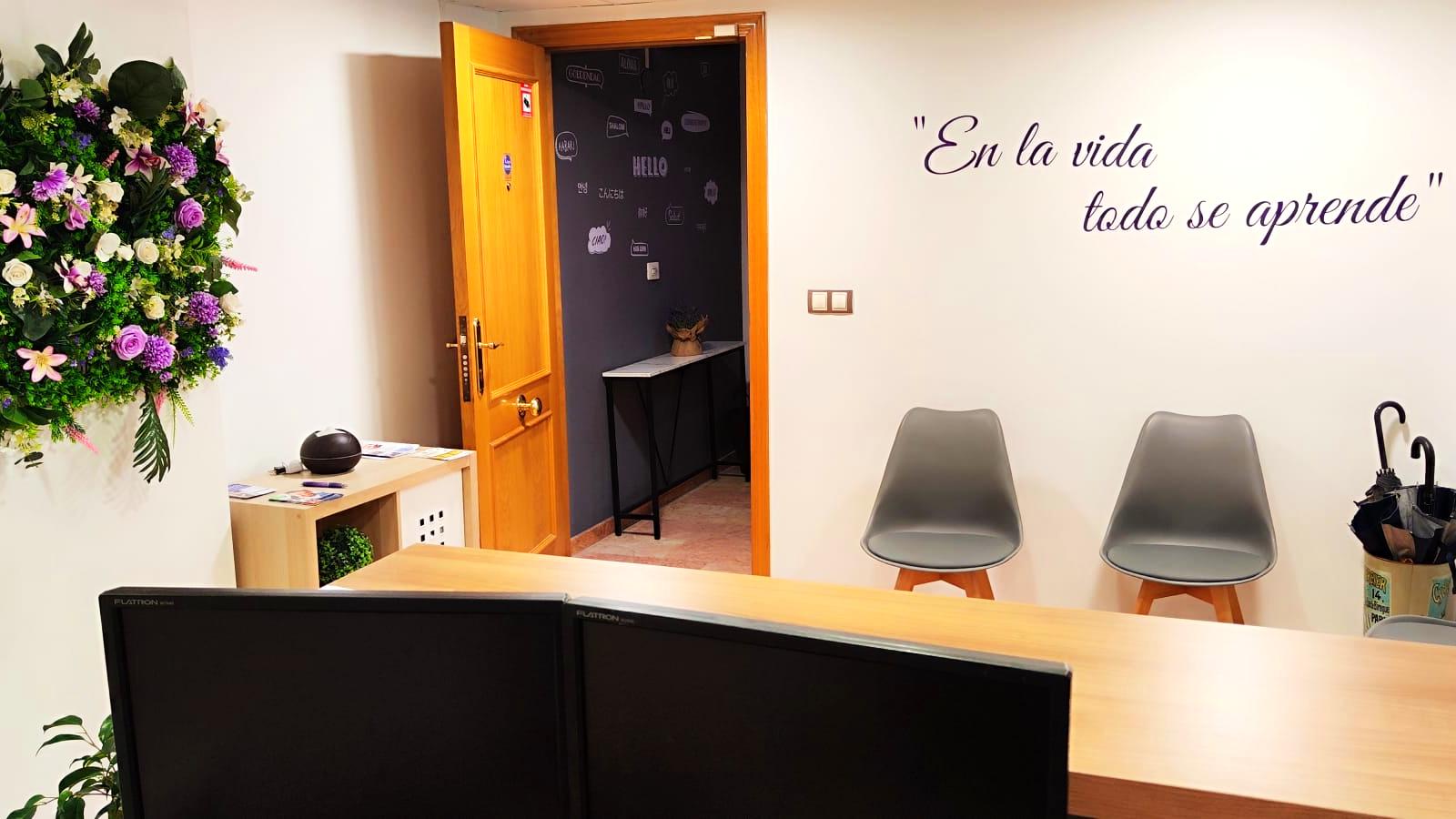 Recepción de Tecni Estudio con sillas de espera y frase motivadora en la pared.